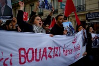 Protester holding Tunisian flags and a banner "Mohamed Bouazizi, "Hero of Tunisia""
