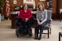 Judith Heumann, on the left in a wheelchair posing with Caroline Kennedy on the right both smiling.