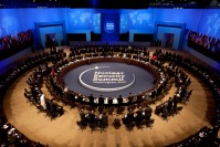 World leaders in roundtable, observing a minute of silence. In the middle, the sign "Nuclear Security Summit Washington, 2010"