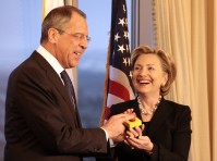 Hillary Clinton and Lavrov laughing together, both holding a restart button.