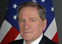 Richard Holbrooke headshot with the US flag in the background.
