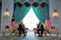 Barack Obama meeting with Najib Razak, seating in front of their respective countries' flags.