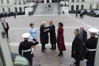 Barack Obama shaking hand with Donald Trump, accompanied by Michelle Obama and Melania Trump.